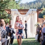 funny photo of a mom running away with a crying baby just before couple exchanges first kiss