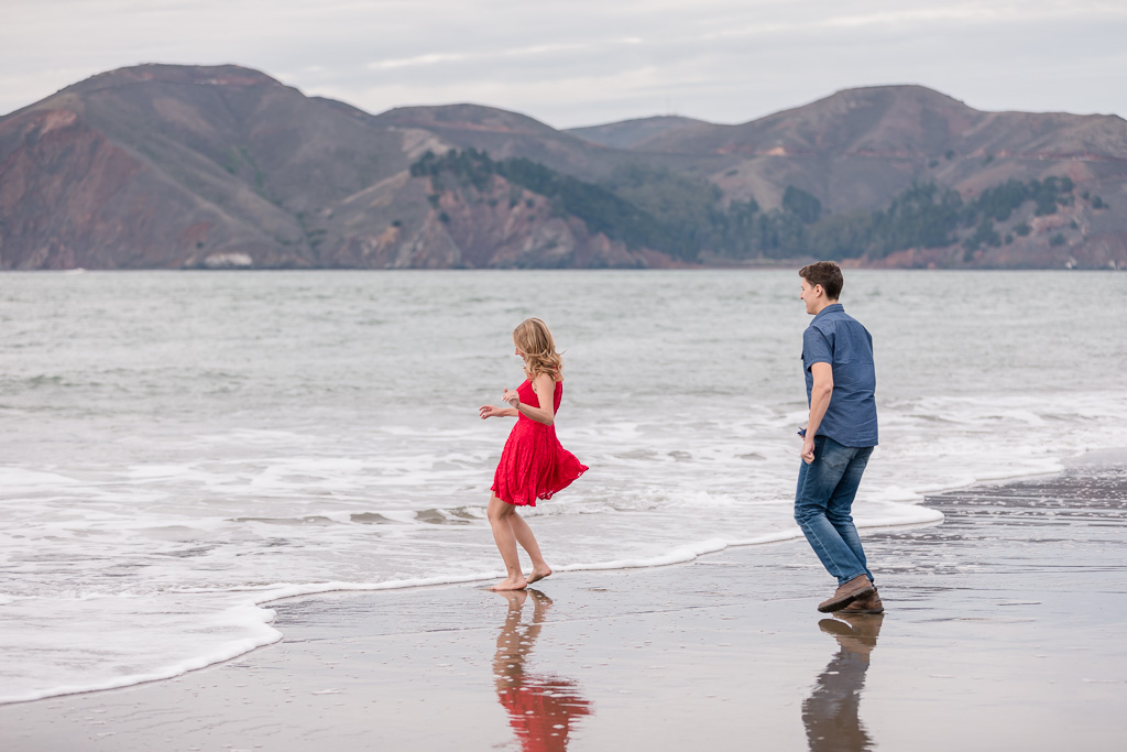 playful and fun engagement photo by the beach