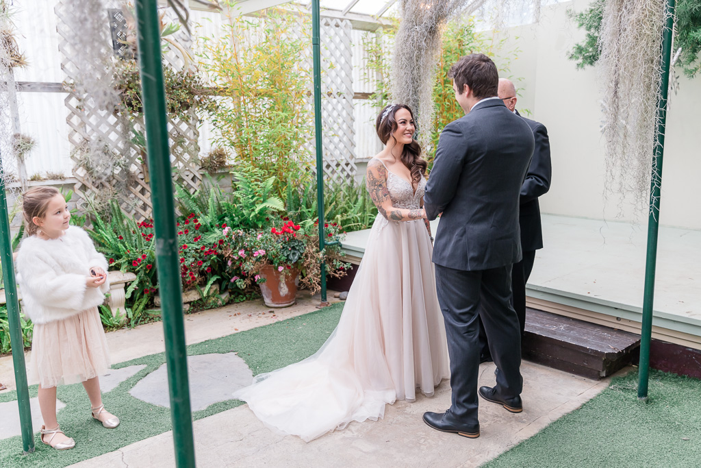 bride and groom being married inside a greenhouse