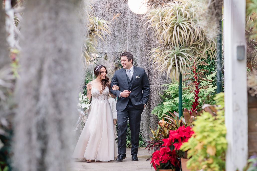 bride and groom candid moment with lush colorful greenery
