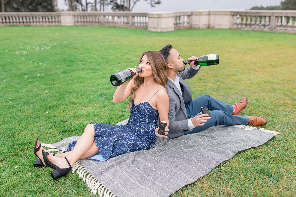 fun loving San Francisco couple taking engagement photos while drinking champagne straight out of a bottle and eating spam musubi