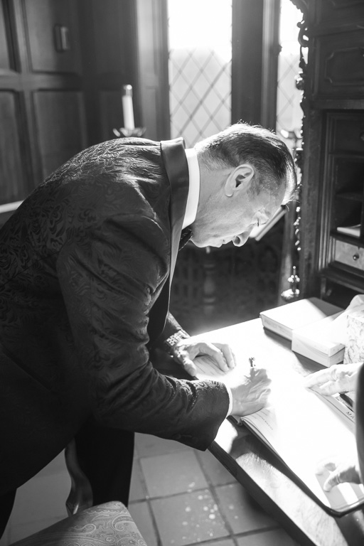 black and white photo of the groom signing the marriage license