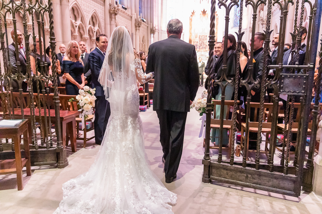 bride being escorted by father down the chapel aisle