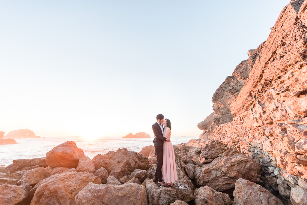 couple kissing under the sunset by the sea