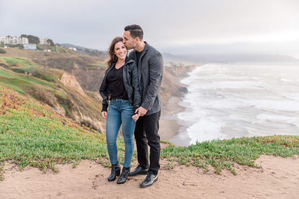 cliffside engagement photo by Pacific Ocean waves