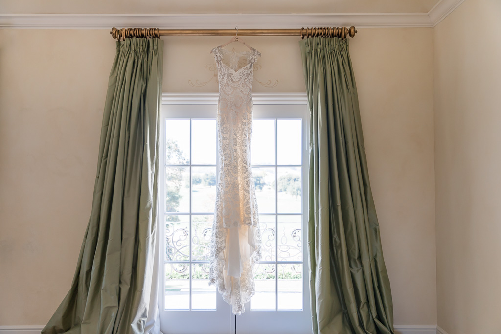 Galia Lahav wedding dress hanging on the floor to ceiling window