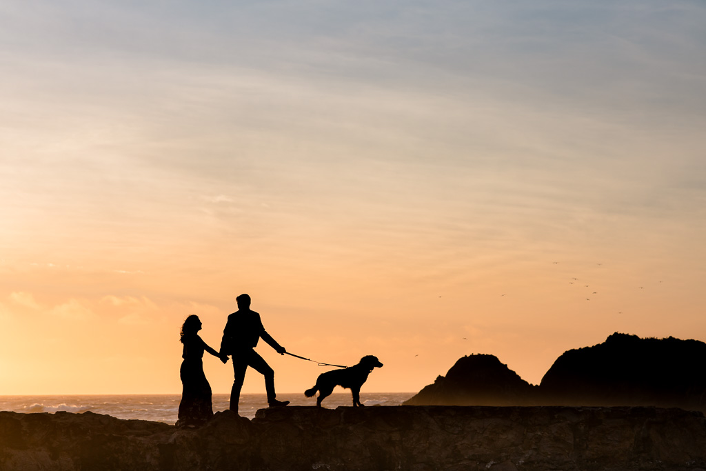 romantic silhouette engagement photo with a puppy by the Pacific Ocean in San Francisco