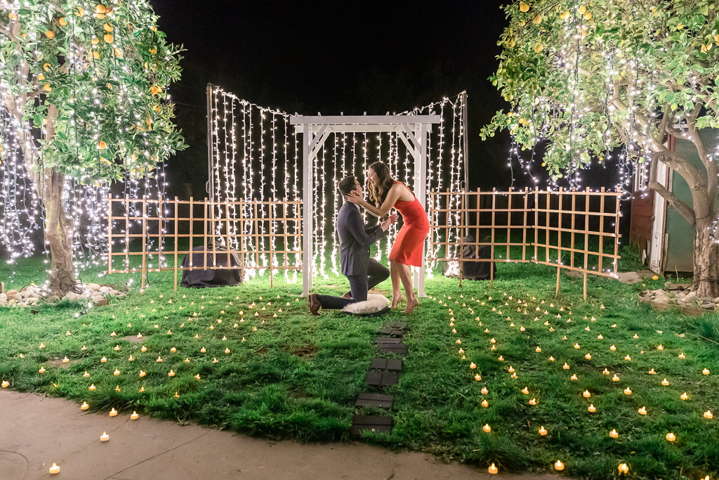 the most romantic and intimate surprise proposal at a enchanting garden decorated with lights all around