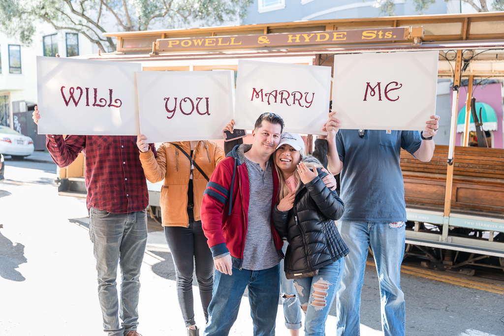 our engaged couple with their will you marry me sign