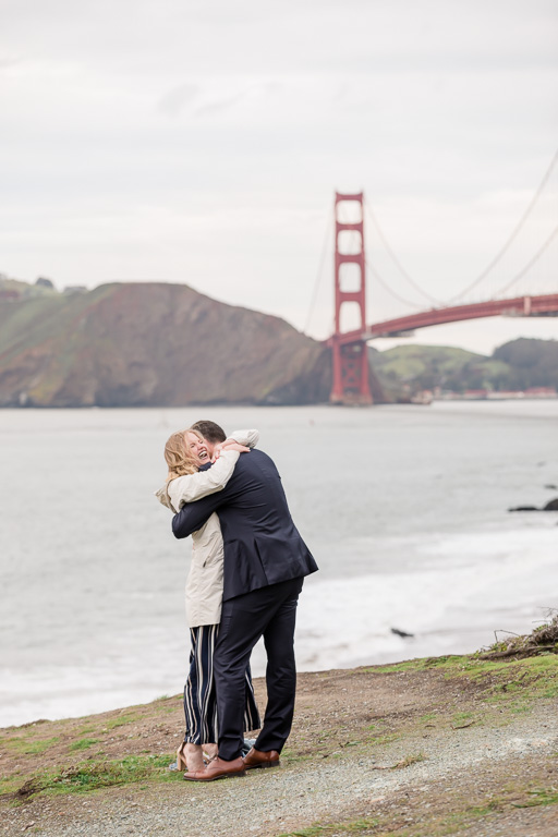 a big hug after she said yes to his proposal in front of the Golden Gate Bridge