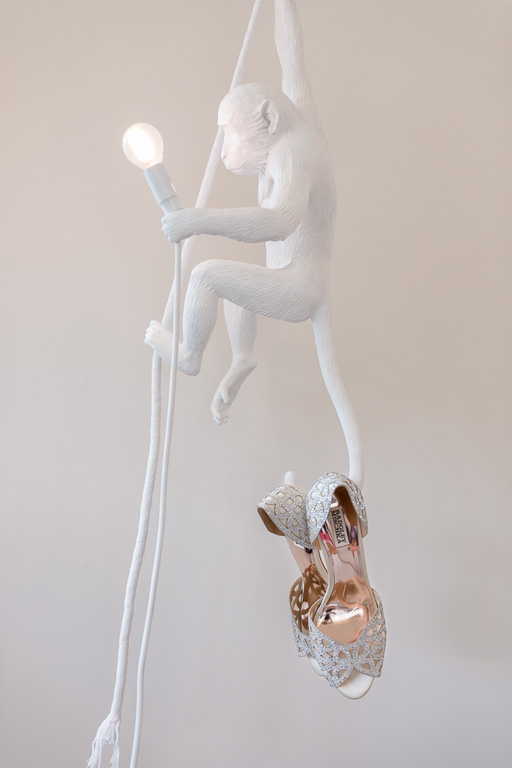 bridal shoes hanging on a seletti monkey lamp