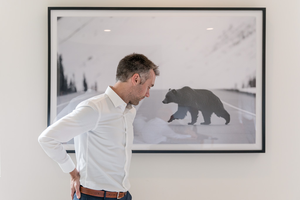 groom getting ready in front of a big bear picture