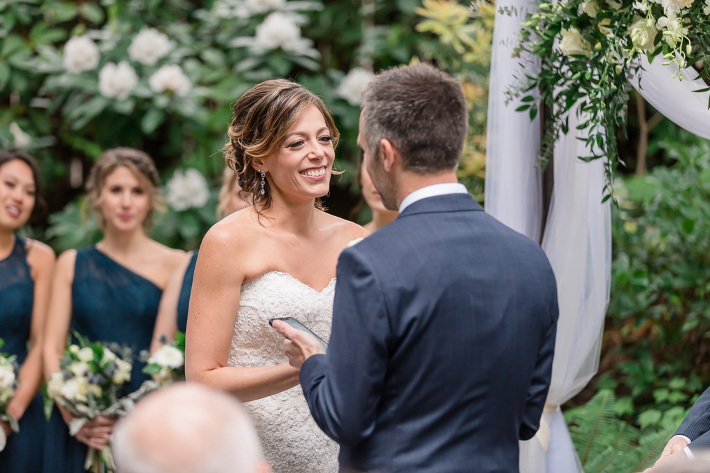 bride smiling at groom when he reads his touching vows