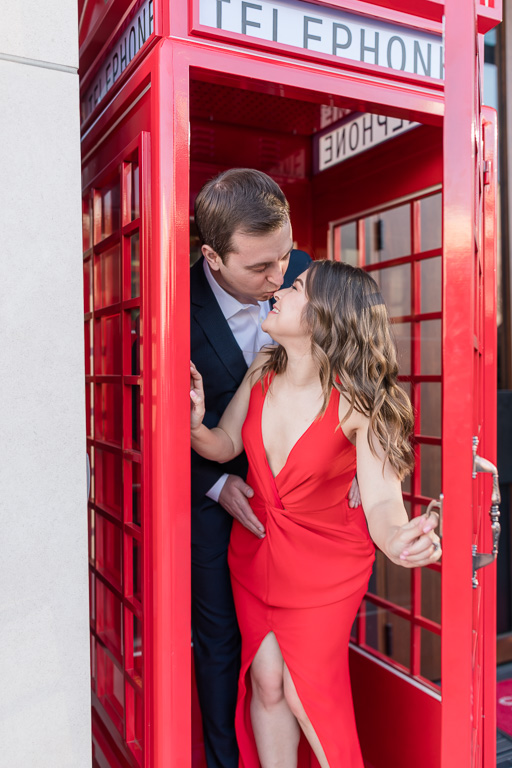couple kissing inside the bright red photo booth