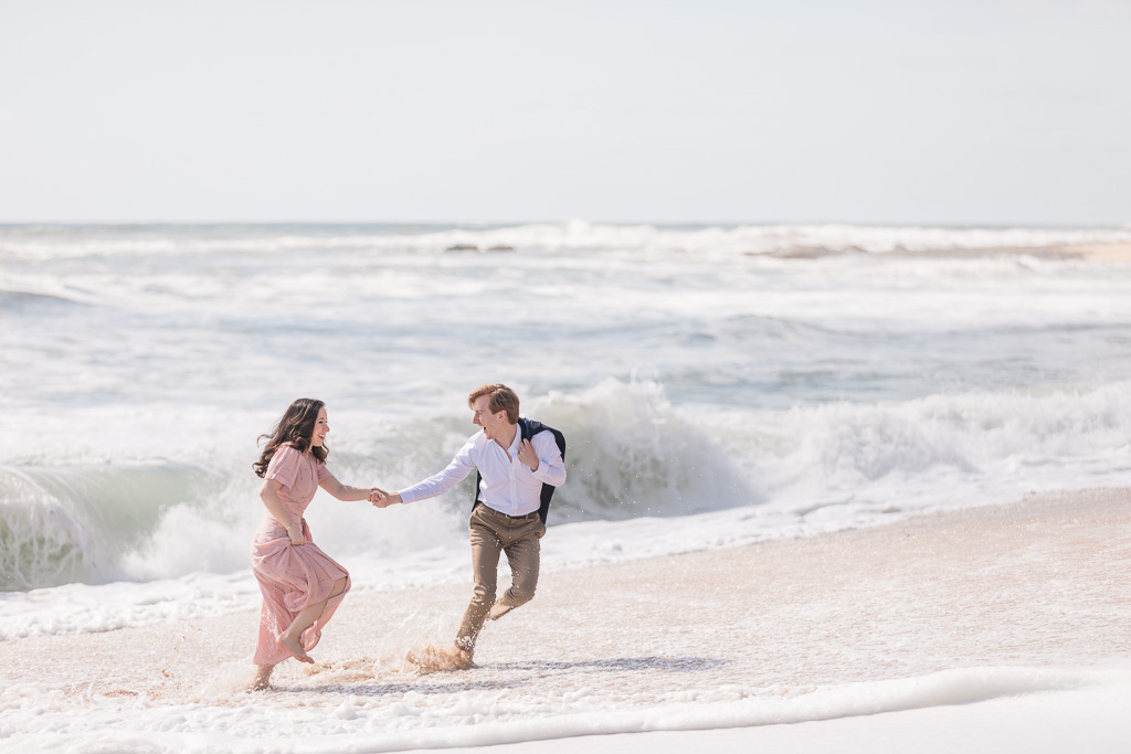 San Francisco happy engagement photo playing in the ocean running on the beach