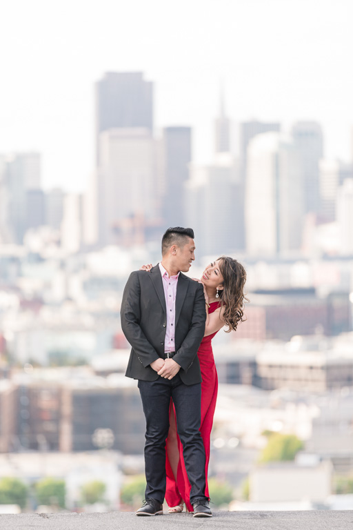 couple standing at a hill overlooking SF skyline