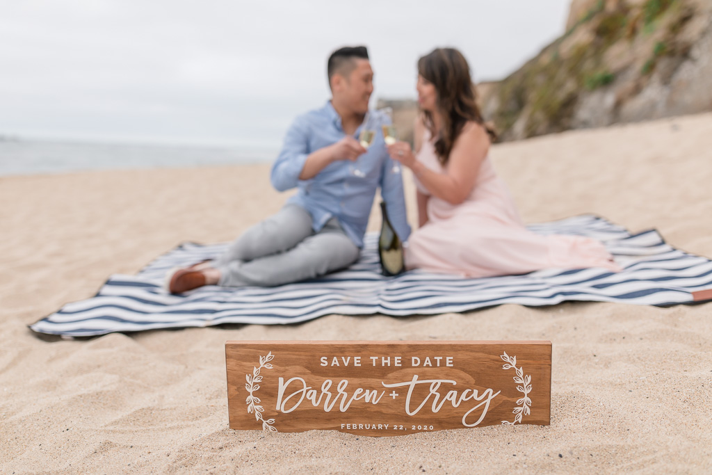San Francisco save the date photo on the beach with a cute wooden engraved sign