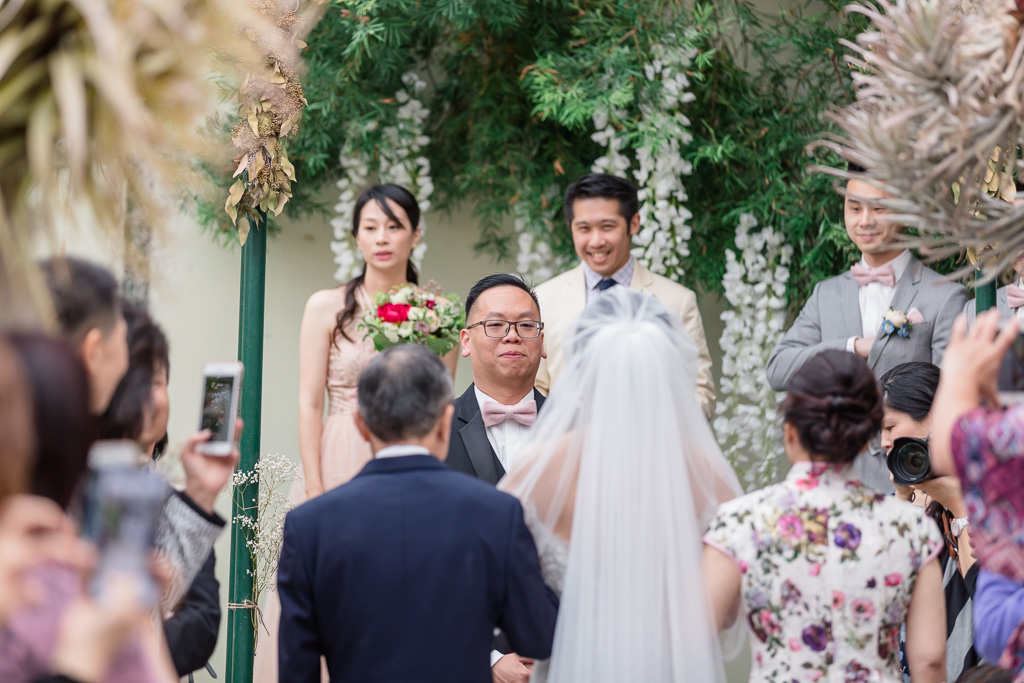 groom staring at his bride walking down the aisle