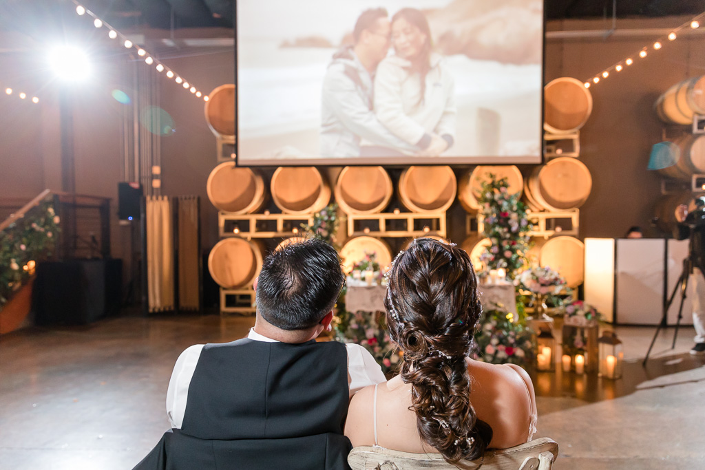 bride and groom watching their San Francisco wedding same day edits at reception
