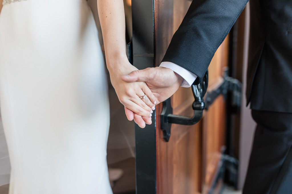 bride and groom first touch by holding hands before their ceremony