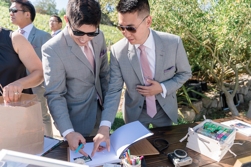 groomsmen putting their names down in the sign-in book