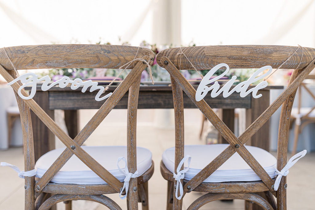 wooden groom and bride signs hanging on the chairs