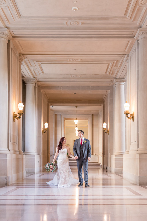 newlyweds walking on the SF city hall marble floor