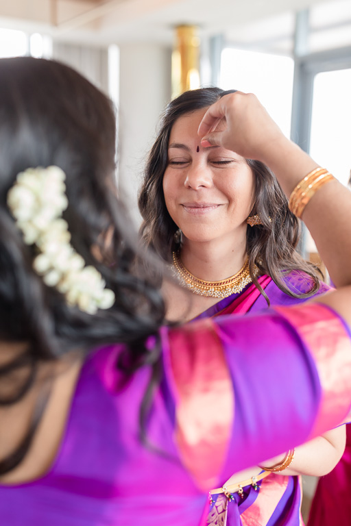 putting on the bindi for a bridesmaid