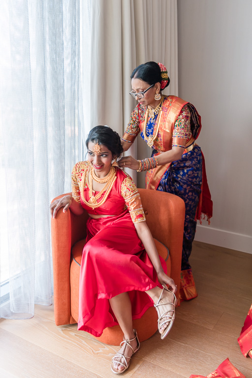 mother helping the bride to get in her sari