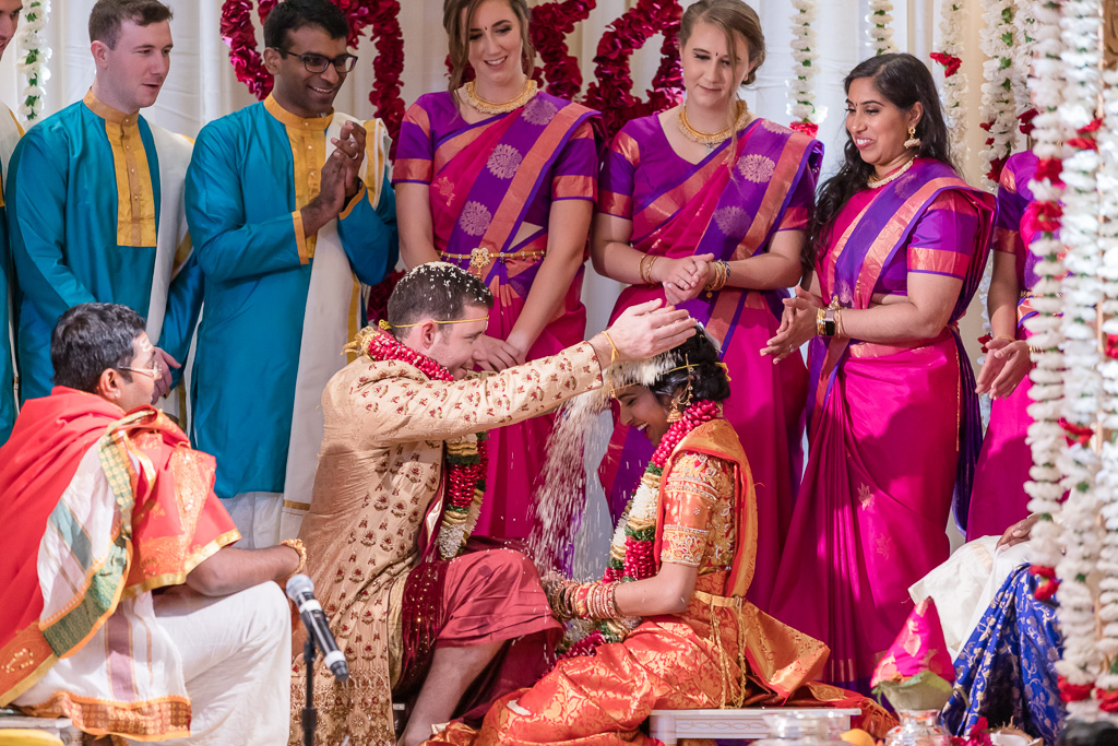 groom pouring rice over bride's head