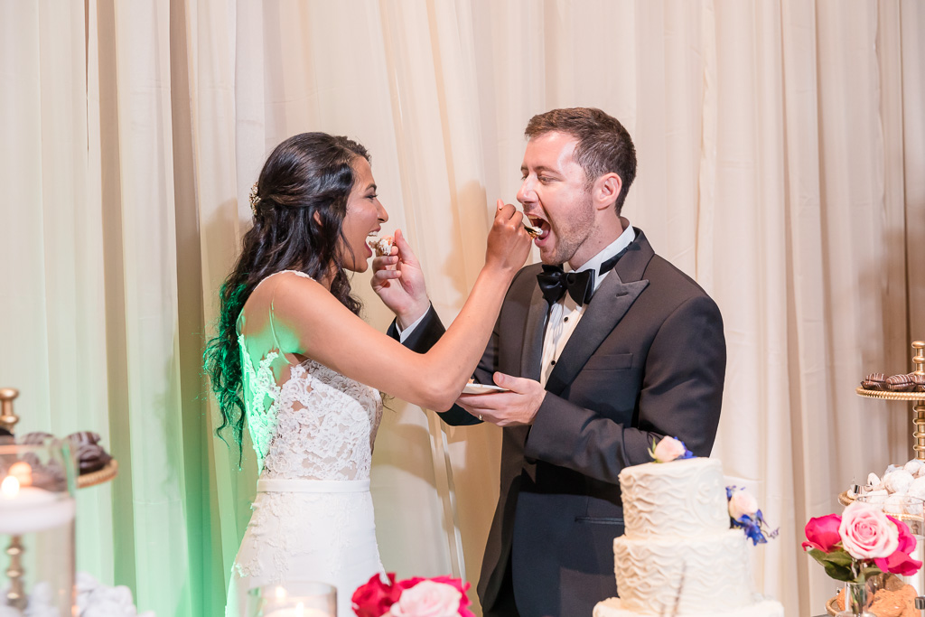newlyweds feeding each other wedding cake