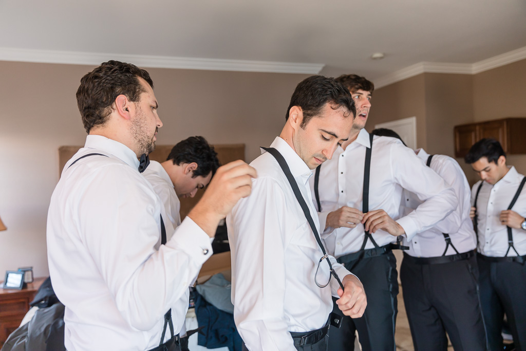 groom getting ready with the help of his groomsmen