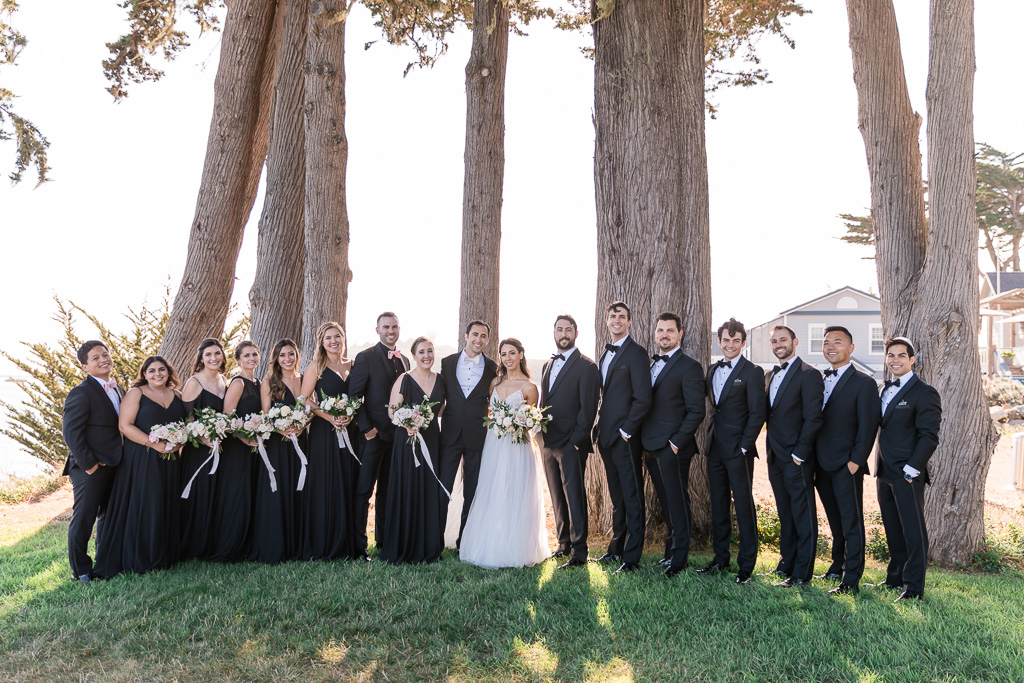 trendy wedding party wearing black dresses and tux