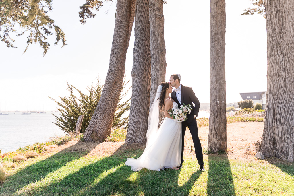 Half Moon Bay wedding sunset photo by the water with sunlight shining through the trees