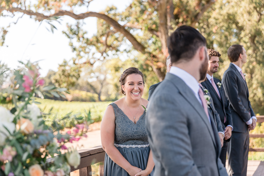 groom and sister laughing during ceremony
