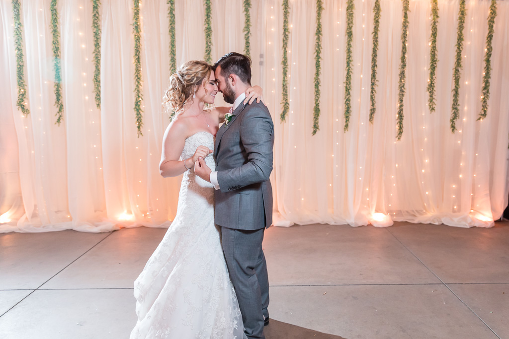 first dance in front of the lit-up draping