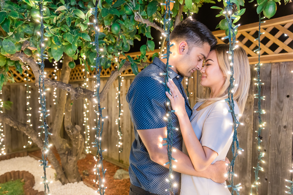 nighttime engagement photo with lemon tree and string lights