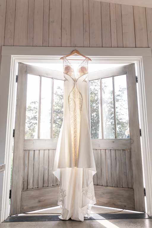 see-through wedding gown hanging in the bridal suite