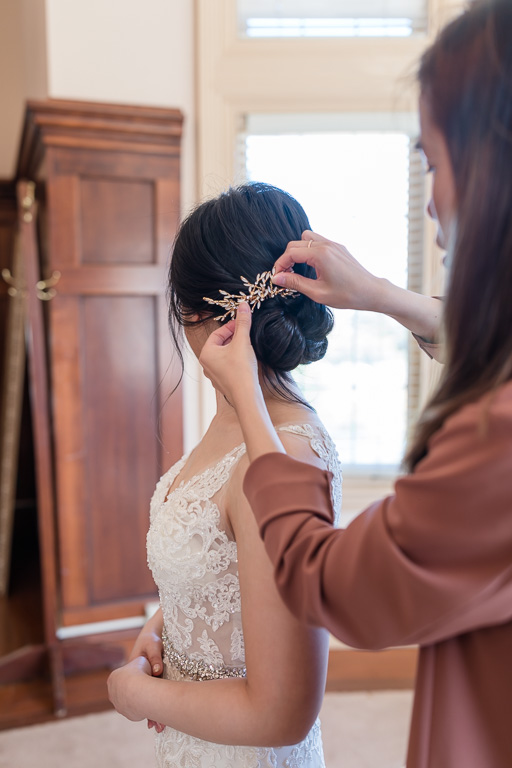 putting on hairpiece on the bride's updo