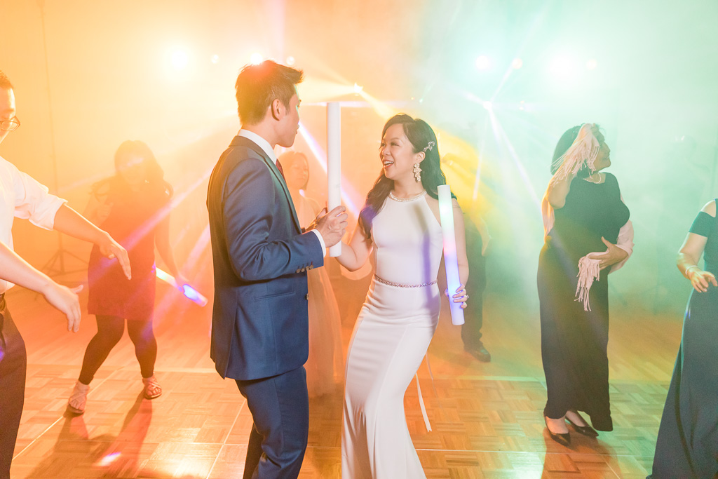 bride and groom dancing in the colorful lights