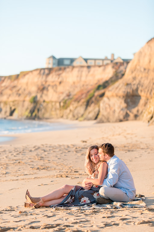 couple snuggle on the golden soft sand beach in Half Moon Bay
