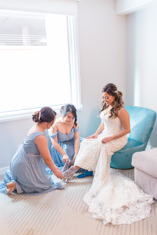 bridesmaids helping the bride to put on her boots