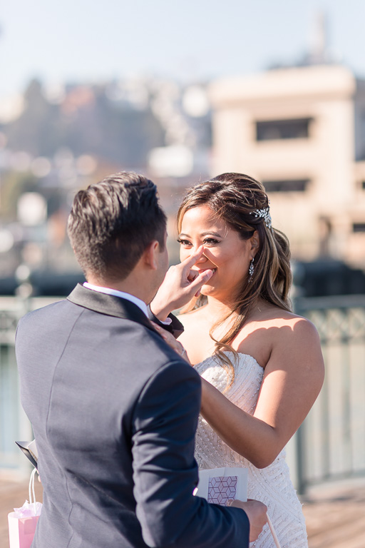 groom wiping bride's happy tears at their first look at downtown San Francisco