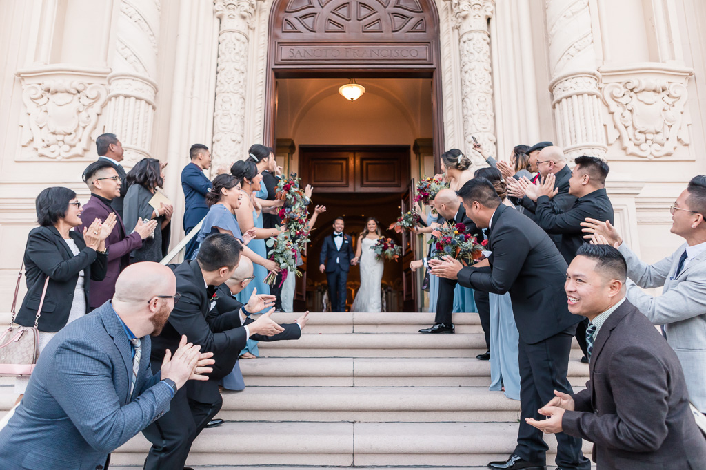 friends and family lining up for the groom and bride to exit Mission Dolores Basilica