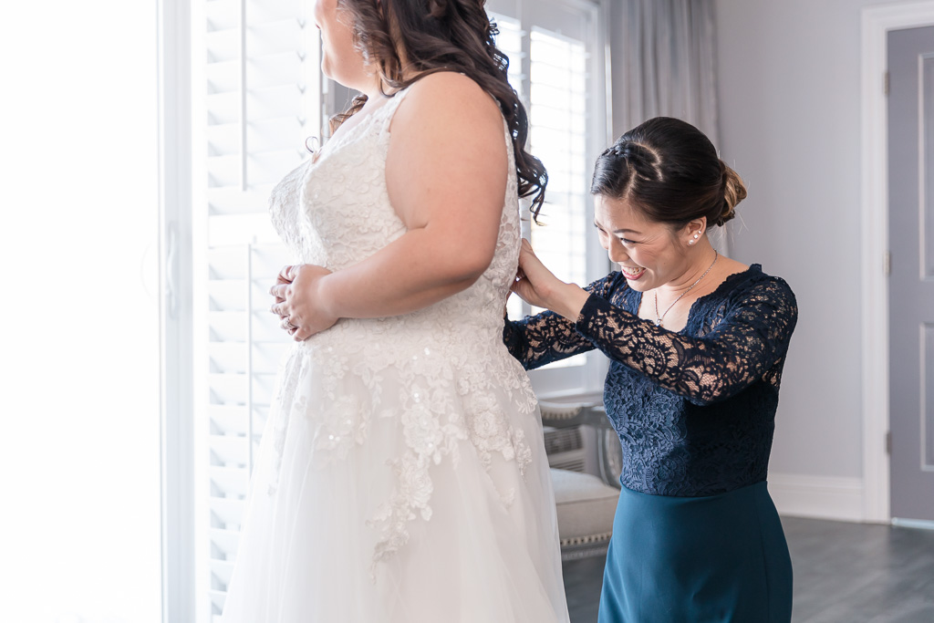 maid of honor helping the bride with her dress
