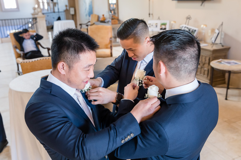 groomsmen pinning each other's boutonnieres