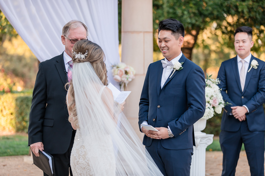 groom smiles during bride reading her vows