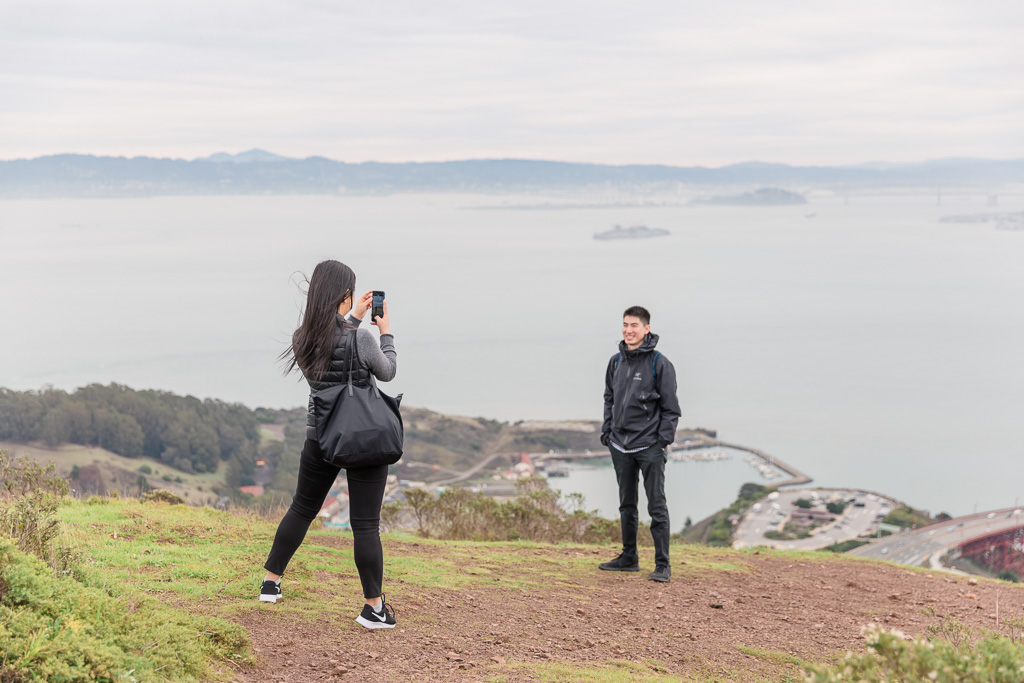 couple taking photos of each other on top of Marin Headlands