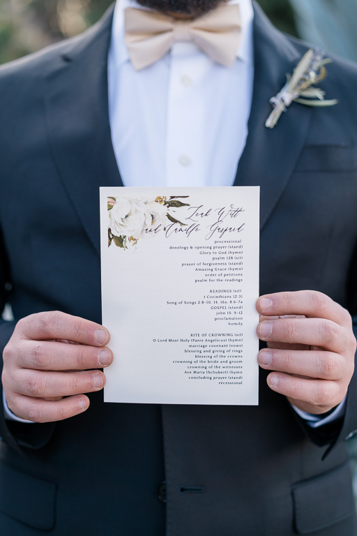 groom holding the invitation