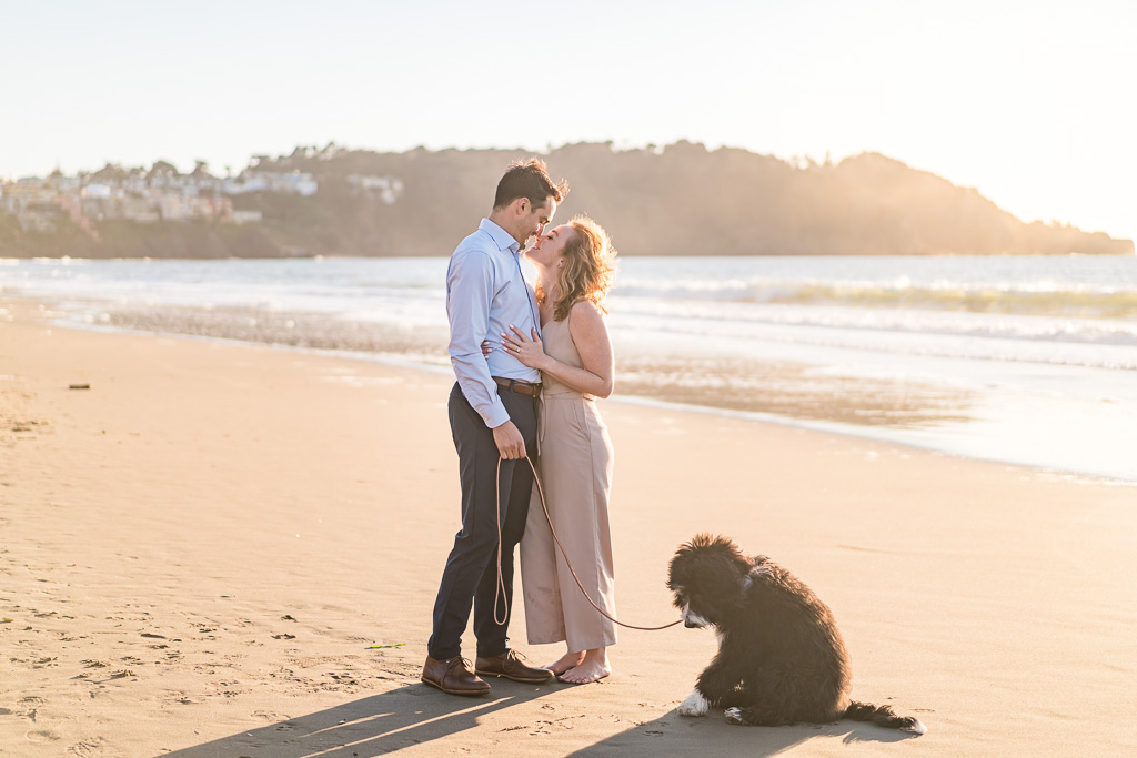 romantic engagement photo on Baker Beach with puppy